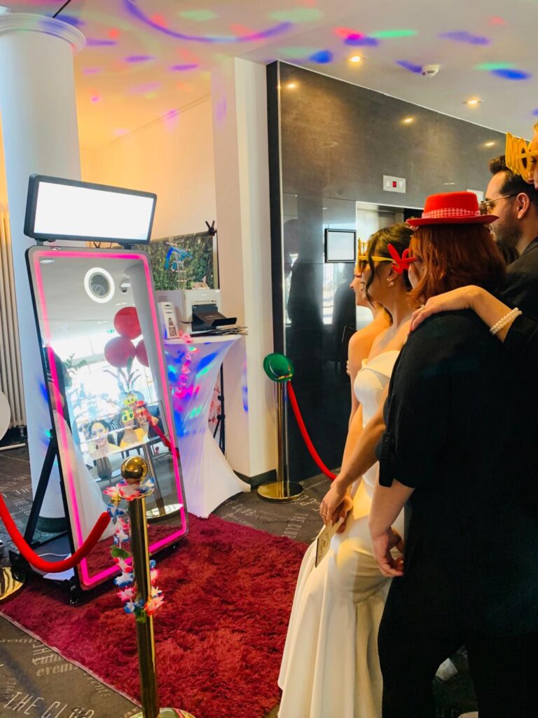 Braut und Gäste posieren für ein Foto vor dem Magic Mirror.